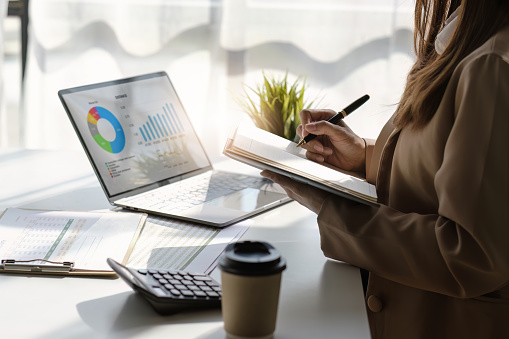 Asian Business woman working at home office and analyze financial report document. Accounting and Finance concept