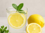 What are the Health Benefits of Lemon for Chronic Illness Lemon water in a glass surrounded by lemon slices and herbs, representing natural health benefits.