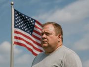 Obesity Crisis in America: How Bad Is It? Middle-aged man sitting at a table, appearing concerned about health and obesity.